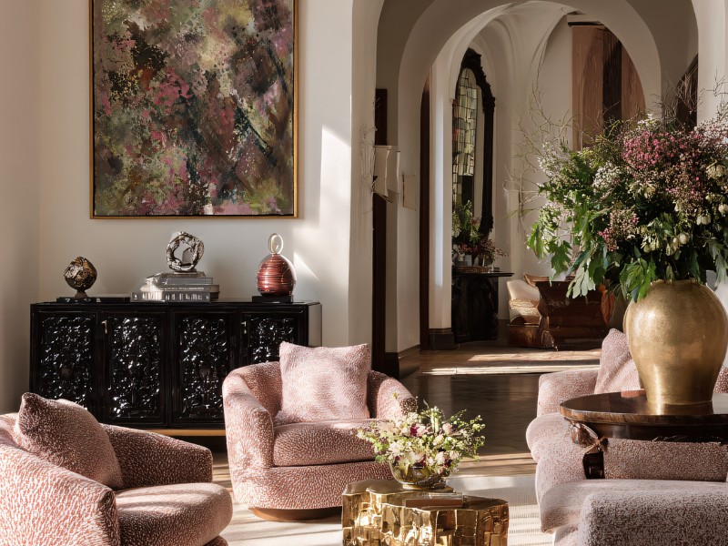 Gestalten Sie Ihre Räume nach Ihren Bedürfnissen und mit Dingen, die Ihnen wichtig sind Individuell gestaltetes Altbau-Wohnzimmer mit rosa Sesseln, Gemälde, opulentem Blumenstrauß und antiker Kommode